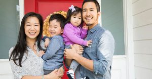 Portrait of mid adult couple and two young children on porch